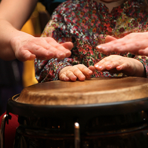 music teacher showing a student how to play hand drums