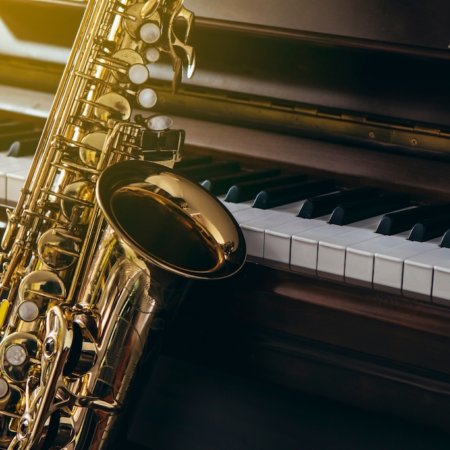 saxophone leaning up against a piano